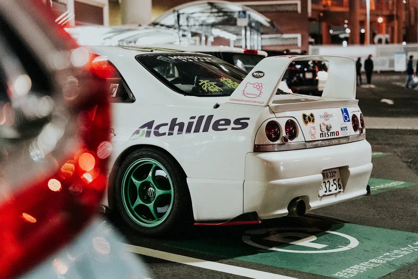 Nissan Skyline blanche lors d’un rassemblement automobile de nuit